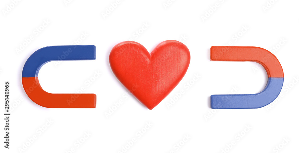Red and blue horseshoe magnets with decorative heart on white background, top view Red and blue horseshoe magnets with decorative heart on white background, top view