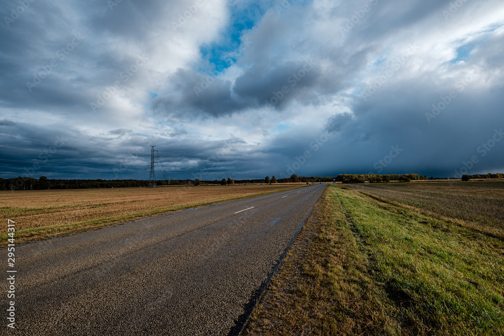 Fototapeta premium storm clouds over asphalt road in perspective