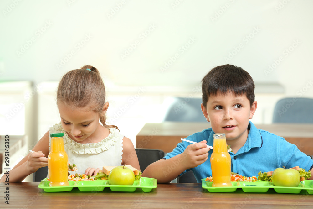 Happy children eating healthy food for lunch in school canteen Happy children eating healthy food for lunch in school canteen