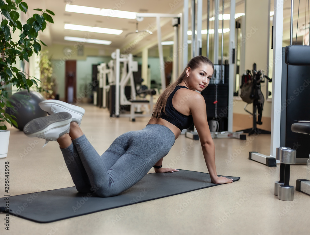 Slim fit woman in sportswear getting ready doing push-ups from the floor in the gym. Healthy lifestyle concept Slim fit woman in sportswear getting ready doing push-ups from the floor in the gym. Healthy lifestyle concept