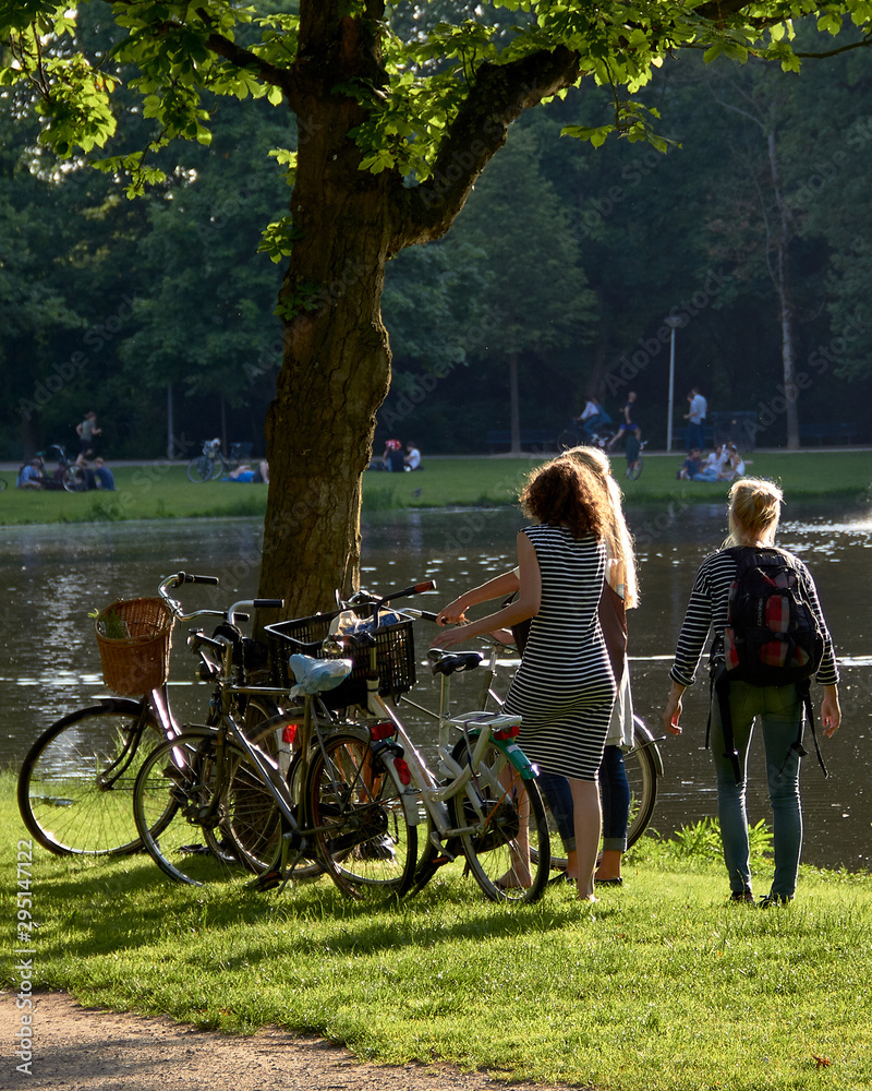 jóvenes en bicicleta junto a un lago