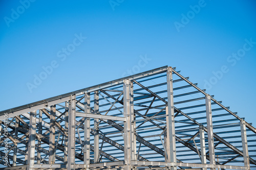 Steel frame workshop is under construction against a blue sky