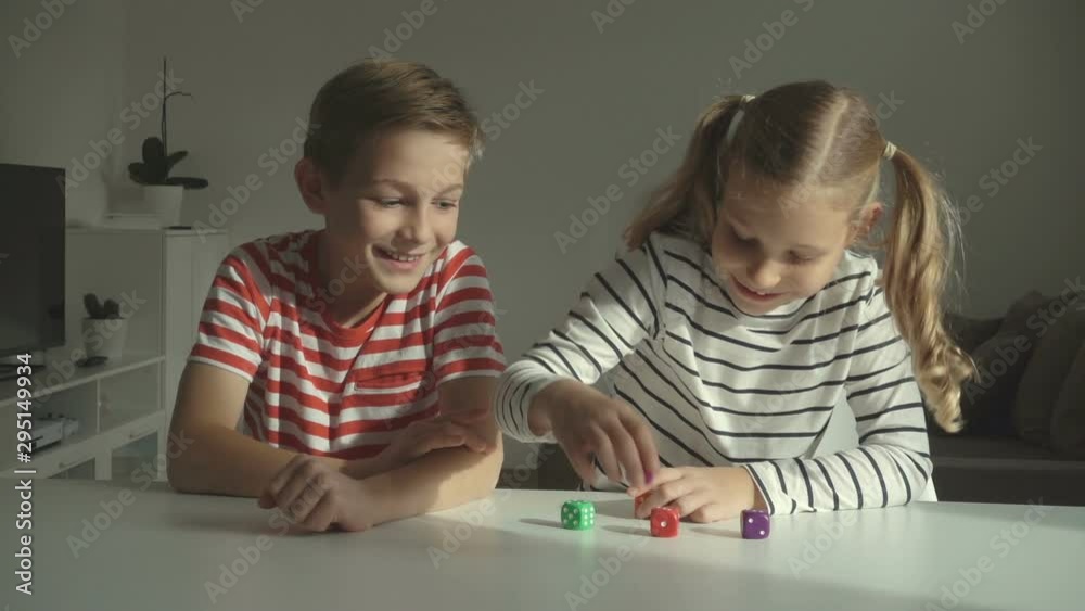 Two happy children playing dices at home Two happy children playing dices at home