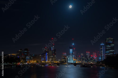 London city skyline at night with full moon