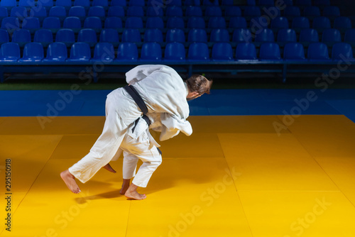 Martial arts. Sparing Portners. Sport man and woman in white kimono train judo throws and captures in the sports hall