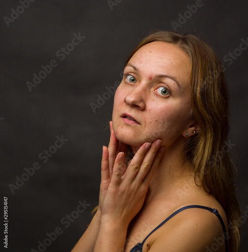 Portrait of young woman, no make up, low key, brown dark hair, no retouch making expressions