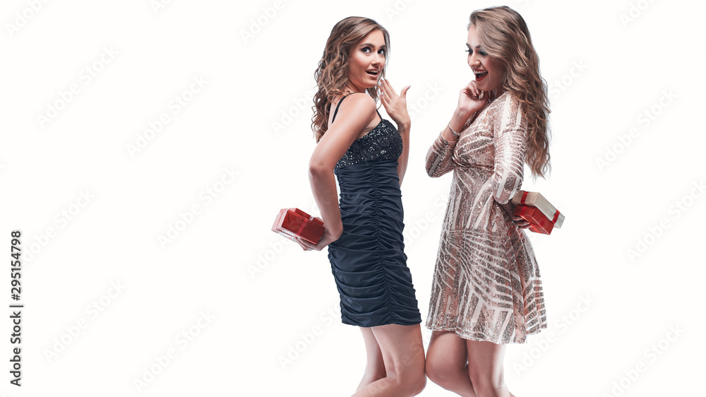 Portrait of young women friends holding gifts behind the back going to exchange them. Portrait of young women friends holding gifts behind the back going to exchange them.