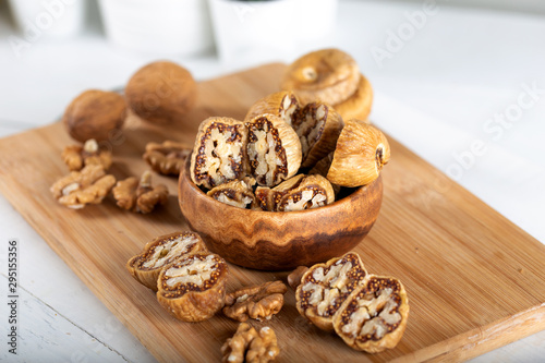 Dried figs with walnuts in wooden bowl.