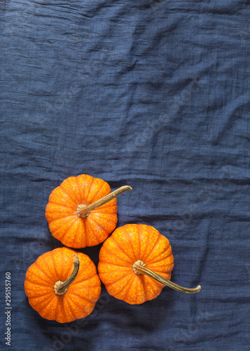 three pumpkins  on blue tablecloth