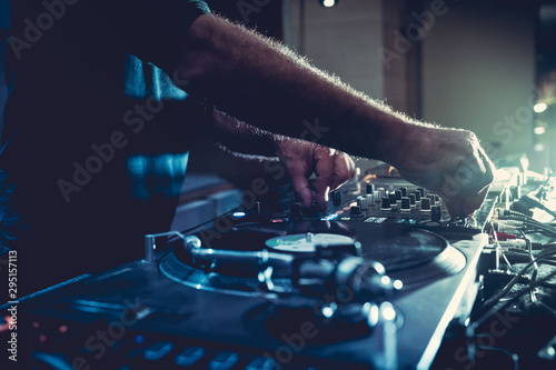 DJ plays music on his deck in party	 photo