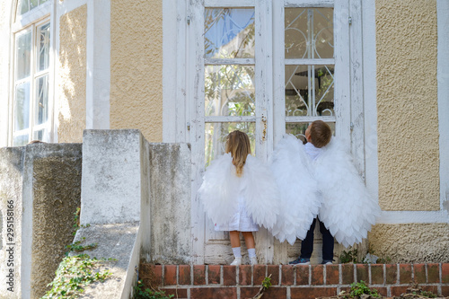 Сhildren dressed as angels stand in front of a closed door