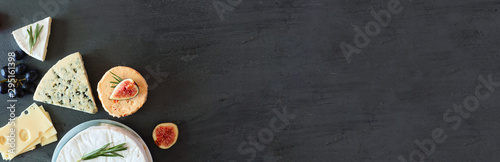 Panel kuchenny z motywem Corner border of a selection of cheeses. Top view banner on a dark stone background with copy space.