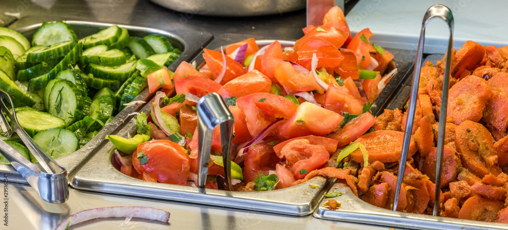 ingredients at a falafel bar with metal vegetable tongs tomatoes carrots cucumber ingredients at a falafel bar with metal vegetable tongs tomatoes carrots cucumber