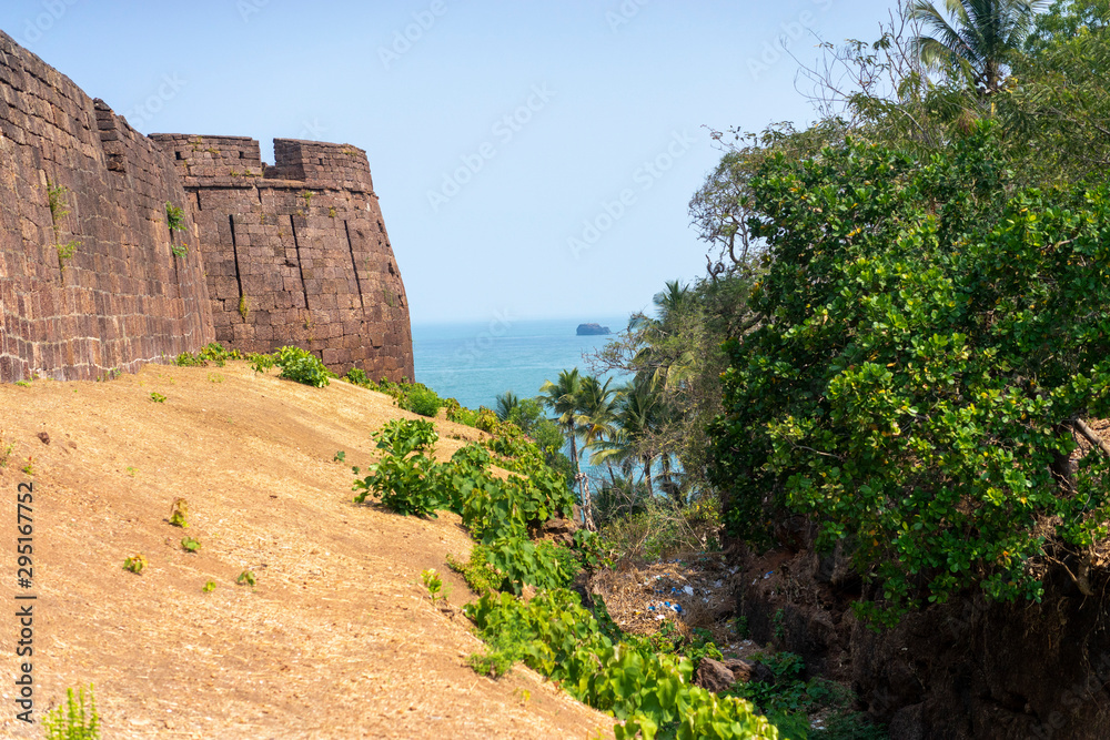 Wall of fort on beach of sea. Goa. India
