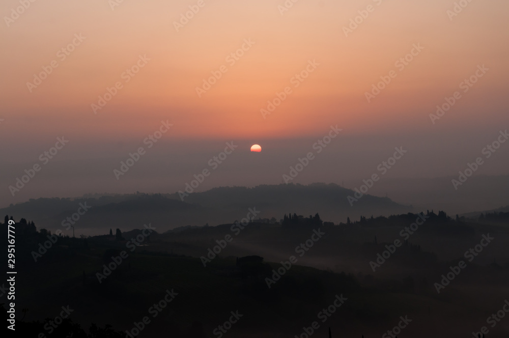 sunrise in a foggy morning - san giminiano tuscany Italy