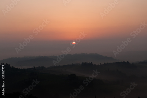 sunrise in a foggy morning - san giminiano tuscany Italy