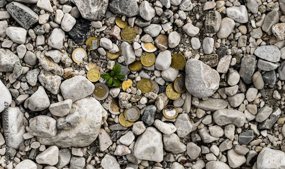 high angle view of euro coins heap among variegated pebble surface high angle view of euro coins heap among variegated pebble surface