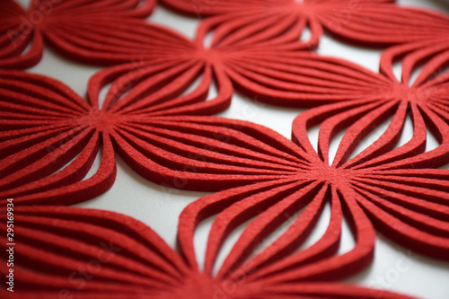Red felt dinner mat on a table with a beautiful pattern  light and shade