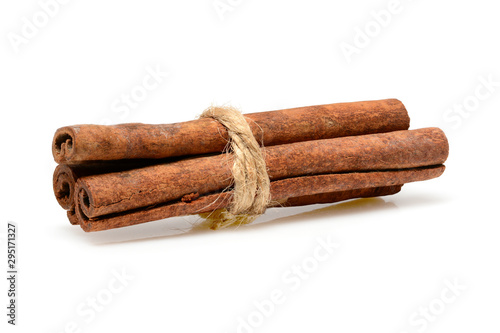 Cinnamon sticks tied with jute rope for cooking and cosmetics. Close up macro isolated on white background with shadow. Full depth of field, high resolution.