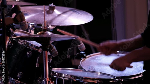 Close-up of the hands of a drummer beating sticks on cymbals of an drum kit. Concert performance of a rock band, jazz band or symphony orchestra. Drum set.