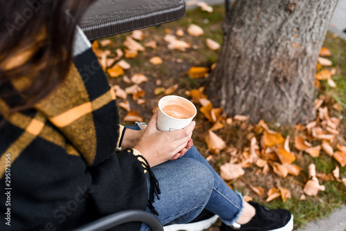 girl holds a cup of latte in her hands. place for your text