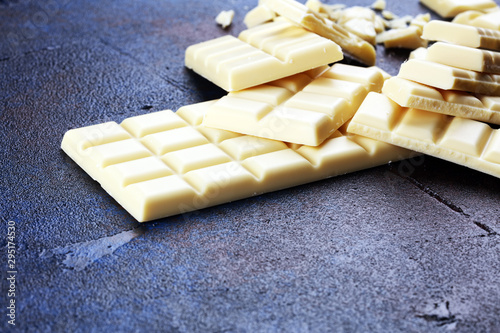 white broken chocolate and cocoa bar. Pieces of white chocolate on rustic background