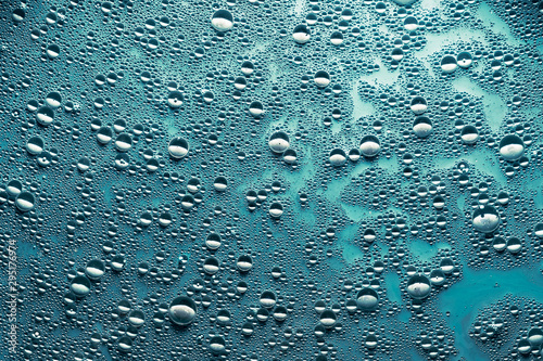 Creative abstract art background. Water drops on blue surface. Bubbled texture effect.