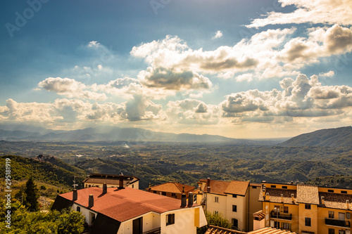 Bellegra, Rome, Lazio, Italy - The panorama seen from Bellegra, with the Prenestini mountains and the Sacco Valley. The cloudy blue sky at sunset. The roofs of houses. Mountains and sunbeams.