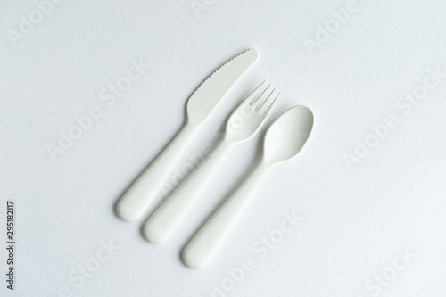 Colored bright plastic dishes beautifully laid out on a white background. Knives  forks  spoons. Menu concept for bar and restaurant. Free space for text. 