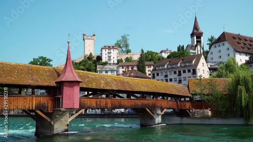 Lucerne / Switzerland - July 4th, 2019: The Spreuer Bridge over the river Reuss with the medieval wall in the background photo