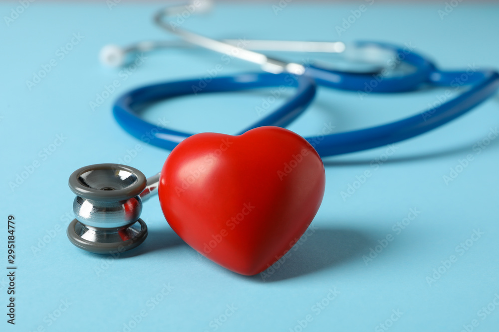 Stethoscope and heart on blue background, close up Stethoscope and heart on blue background, close up
