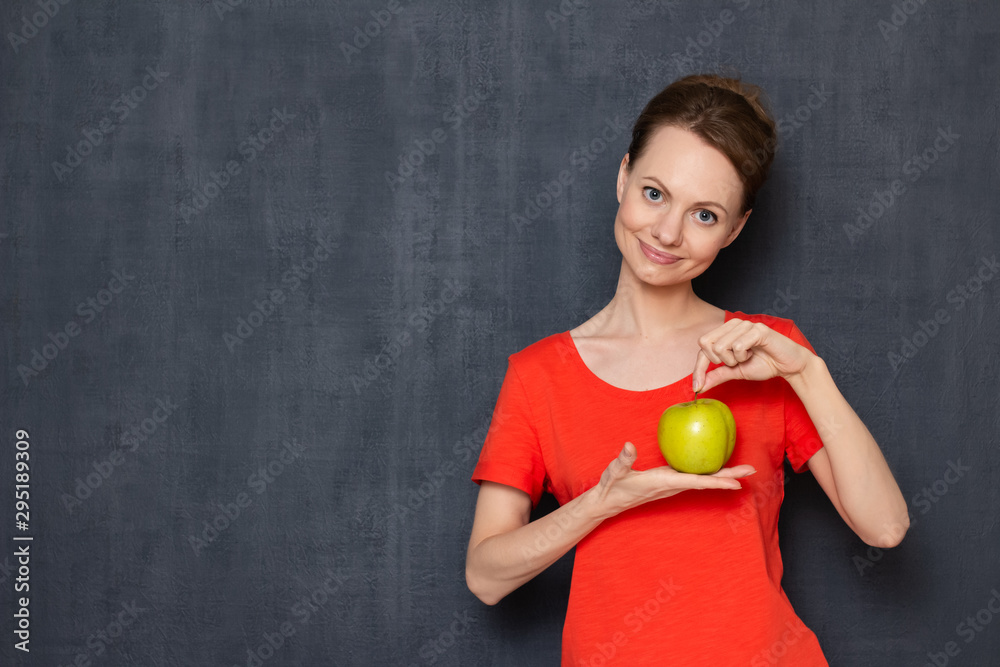 Portrait of happy woman holding ripe yellow-green apple in hands Portrait of happy woman holding ripe yellow-green apple in hands