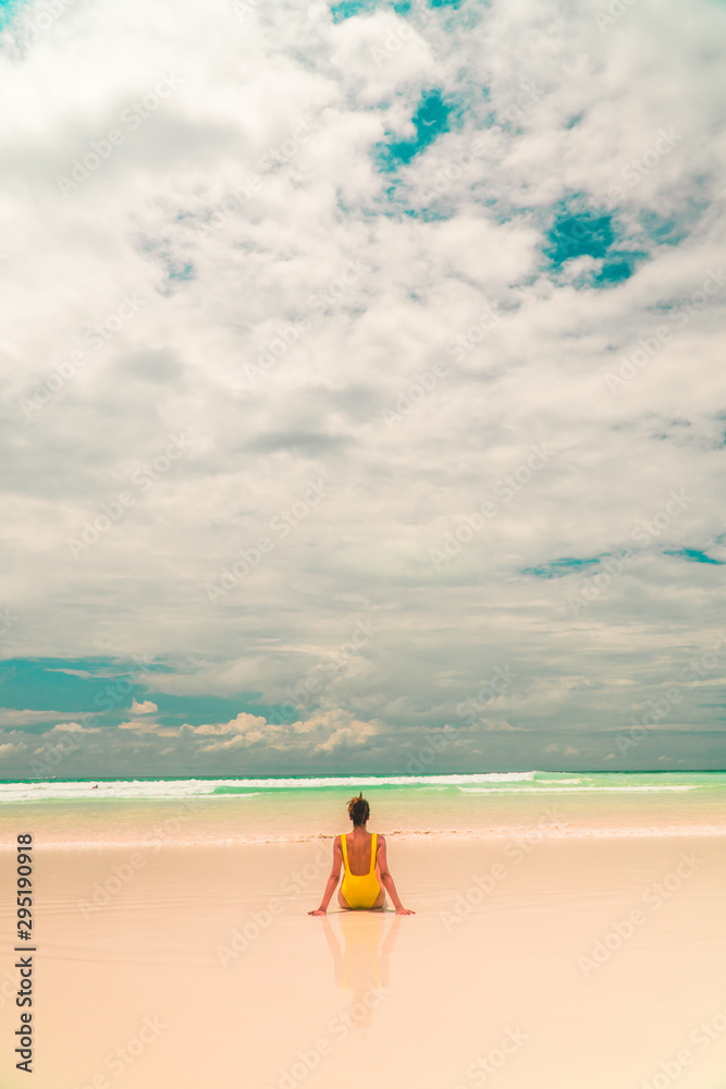 Yellow bikini Woman on beach. Tourist walking along Tropical Galapagos beach with turquoise ocean waves and white sand. Holiday, vacation, paradise, summer vibes. Isabela, San Cristobal