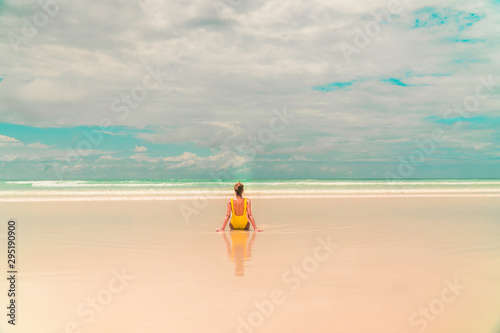 Yellow bikini Woman on beach. Tourist walking along Tropical Galapagos beach with turquoise ocean waves and white sand. Holiday  vacation  paradise  summer vibes. Isabela  San Cristobal