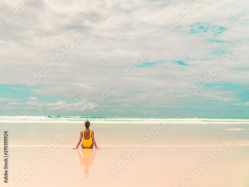 Yellow bikini Woman on beach. Tourist walking along Tropical Galapagos beach with turquoise ocean waves and white sand. Holiday  vacation  paradise  summer vibes. Isabela  San Cristobal