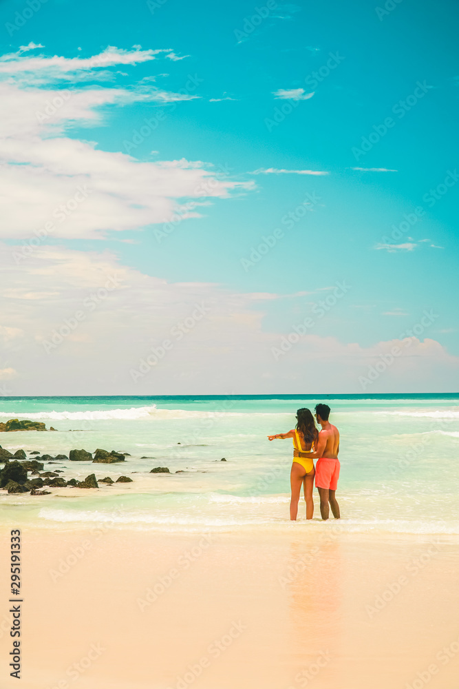 Couple in beach holiday romance. Tourist on Tropical beach with turquoise ocean waves and white sand. Sand bay view. Holiday, vacation, paradise, summer vibes. Isabela, San Cristobal Couple in beach holiday romance. Tourist on Tropical beach with turquoise ocean waves and white sand. Sand bay view. Holiday, vacation, paradise, summer vibes. Isabela, San Cristobal