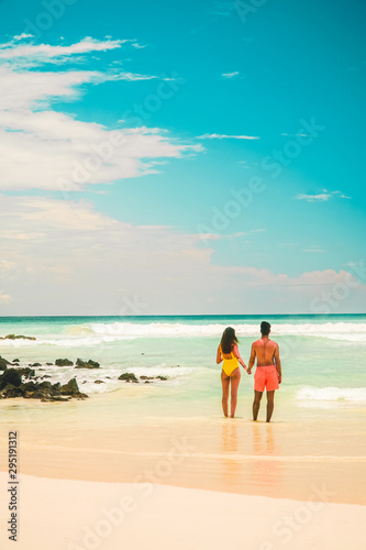 Couple in beach holiday romance. Tourist on Tropical beach with turquoise ocean waves and white sand. Sand bay view. Holiday, vacation, paradise, summer vibes. Isabela, San Cristobal