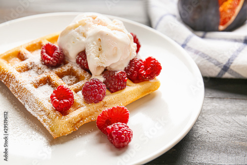 Tasty waffle with ice-cream and berries on plate, closeup