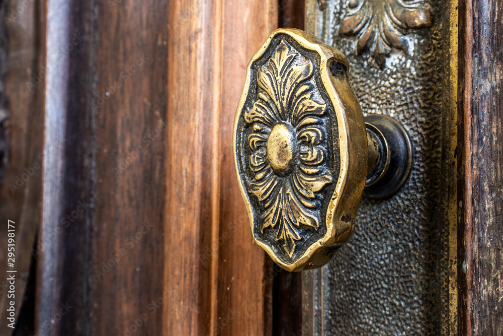 old metal doorknob on an ornate wooden door inside a church in Brazil old metal doorknob on an ornate wooden door inside a church in Brazil