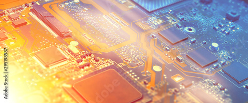 Closeup on electronic motherboard in hardware repair shop, blurred panoramic image with details of the circuitry and close-up on electronics. Picture toned in orange and blue.