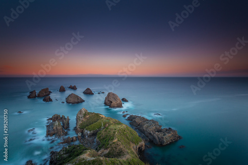 Backlight of sunset with long exposure at Nugget Point Lighthouse South Island New Zealand