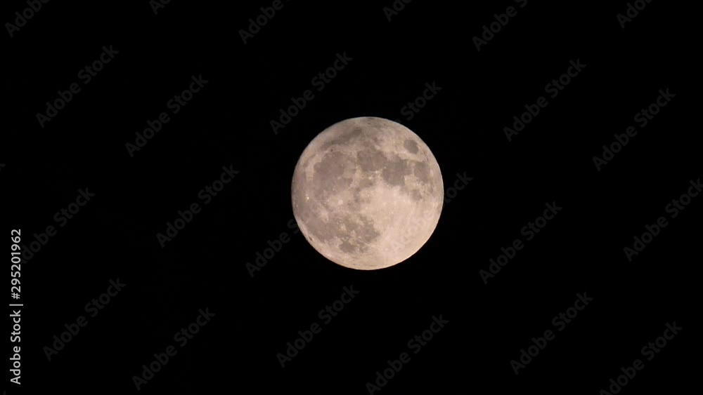 Full Moon Moves in the Night Sky through light clouds. Close up, time lapse. Moonlight Shines in the black night sky. Full Moon Moves in the Night Sky through light clouds. Close up, time lapse. Moonlight Shines in the black night sky.