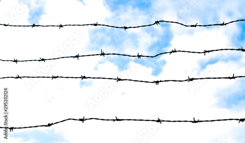 Panoramic image with barbed wire and sky.
