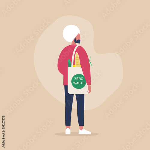 Zero waste concept, young indian male millennial character carrying groceries in a reusable eco friendly shopper bag