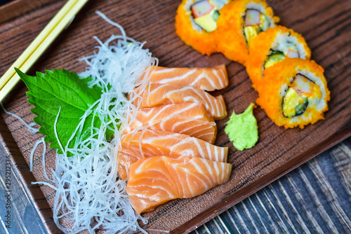 Salmon Sushi is a popular dish in Asia. Black bowl with chopsticks on the table, the concept of restaurant business. photo