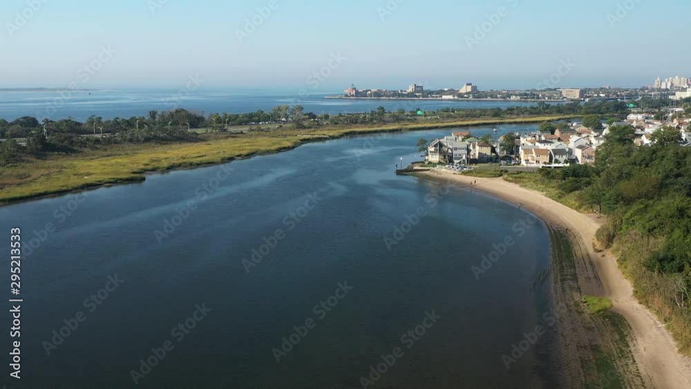 aerial drone dolly shot forward & descend over Shell Bank Creek in Brooklyn, NY toward an old, fat husky in the waters below aerial drone dolly shot forward & descend over Shell Bank Creek in Brooklyn, NY toward an old, fat husky in the waters below