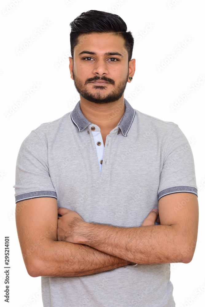 Fototapeta premium Young handsome Indian man with arms crossed looking at camera