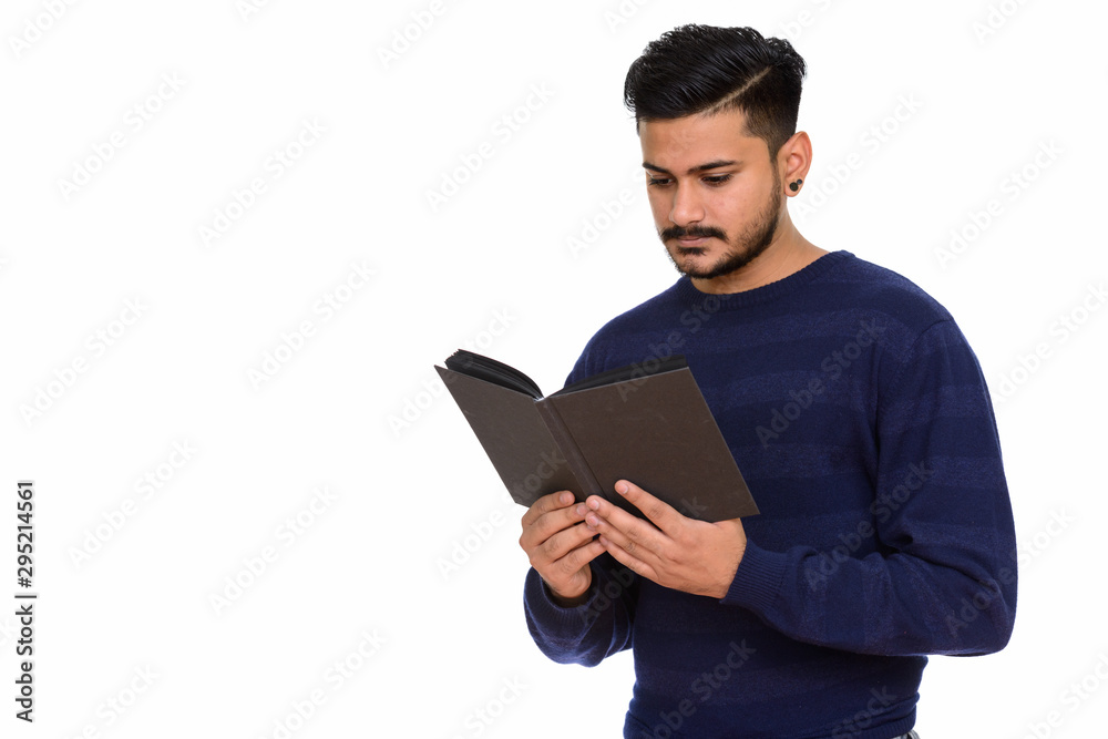 Young handsome Indian man reading book or diary