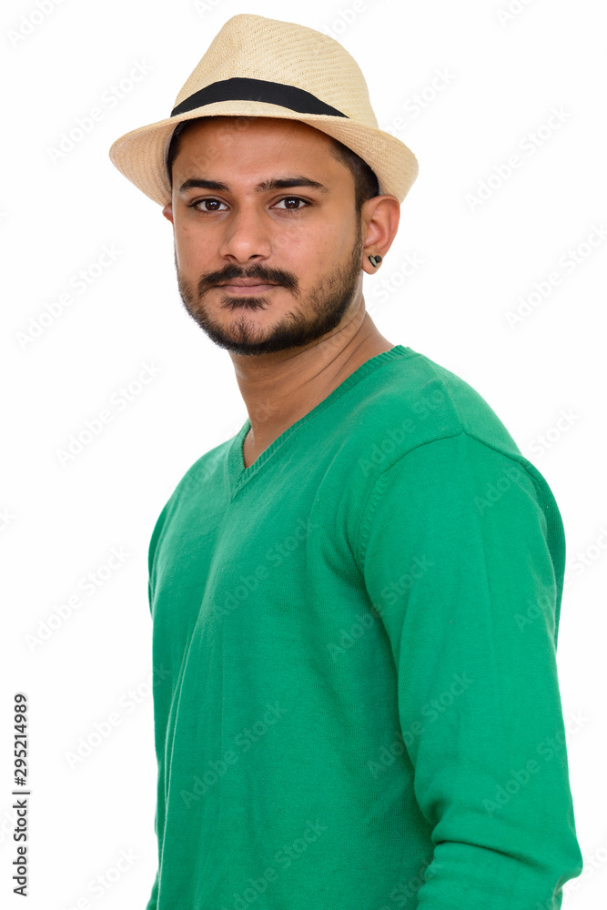 Young handsome Indian man with hat looking at camera
