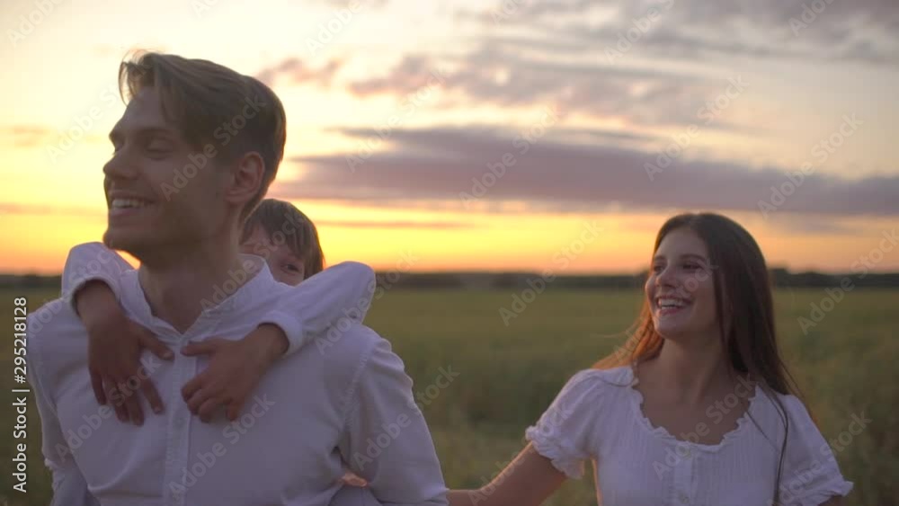 happy family outdoors walking on wheat field with little boy. Mother, father, son child having fun on summer day enjoying nature together, health love travel summertime happy holiday happiness sunset happy family outdoors walking on wheat field with little boy. Mother, father, son child having fun on summer day enjoying nature together, health love travel summertime happy holiday happiness sunset